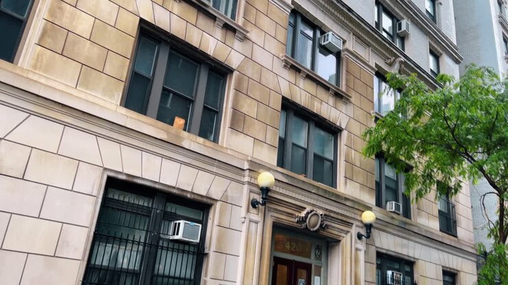 Ingresso classico di un edificio residenziale in brownstone a New York City. Vista dal piano terra di un edificio con facciata in pietra con il numero civico 420 e auto parcheggiate