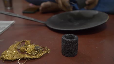 selective focus of an indian goldsmith preparing to melt gold jewelry in a workshop