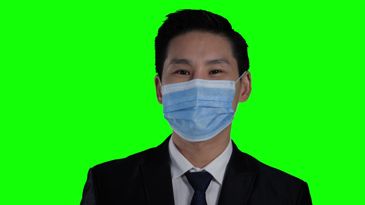 녹색 스크린 또는 크로마 키 배경으로 보호 마스크를 착용 한 아시아 사업가 바이러스 발병으로 모든 사람이 보호 마크를 착용했습니다.