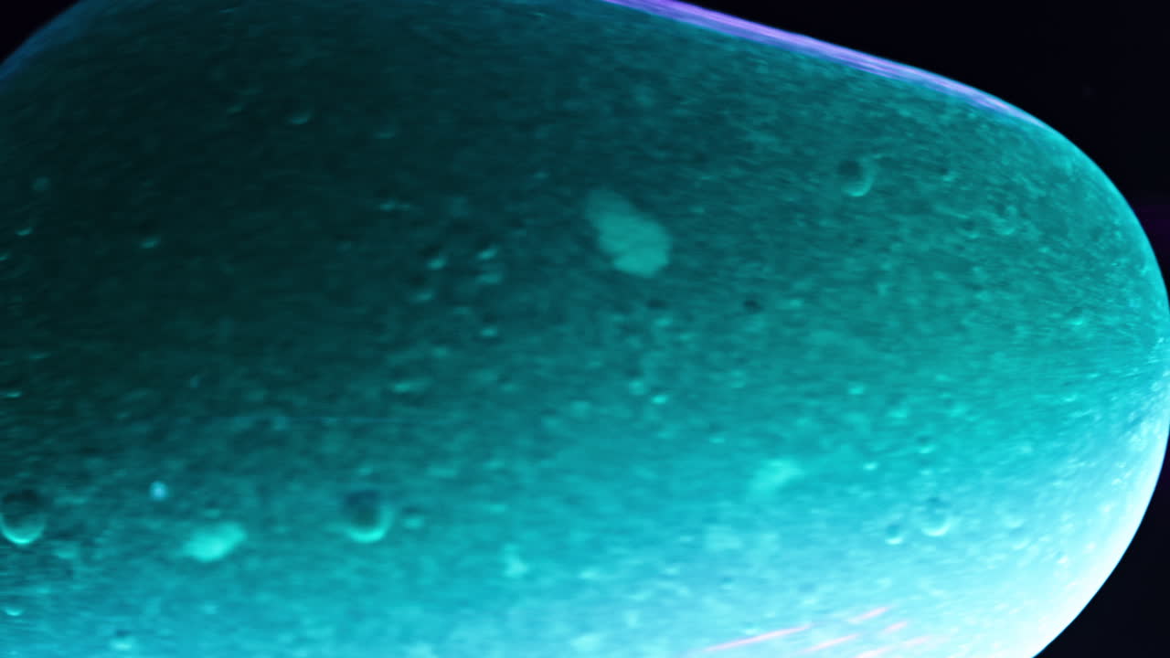 Swirling dark liquid with light reflections and textures, close-up of substances blending together