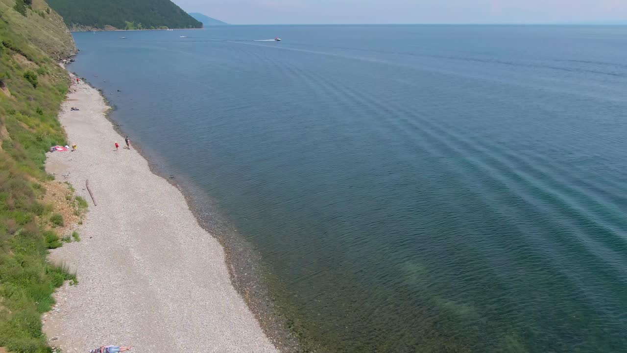 прибрежный ландшафт с людьми и лодками