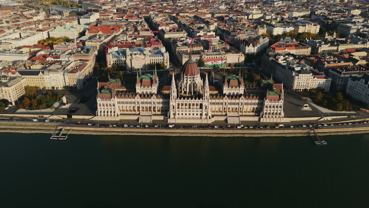 A stunning aerial of the Hungarian Parliament along the Danube, framed by two riverboats gliding through Budapest