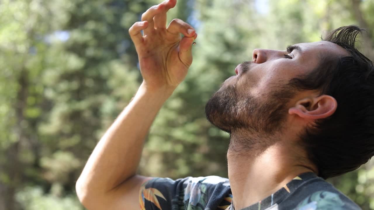 체리를 입에 넣고 씹는 남자의 슬로우 모션 샷