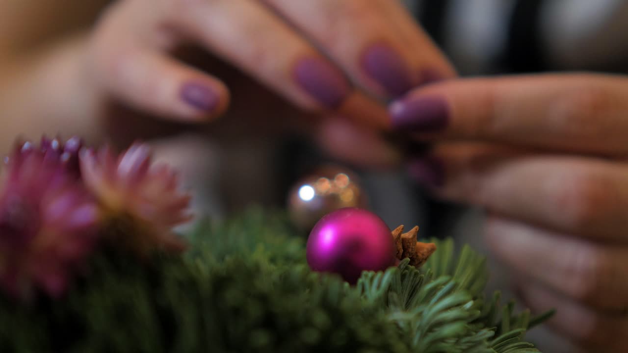 mujer haciendo una corona de abeto para la víspera de navidad y decorándola, decoración artesanal diy, tradiciones de invierno, vacaciones de temporada, manos desenfocadas de cerca