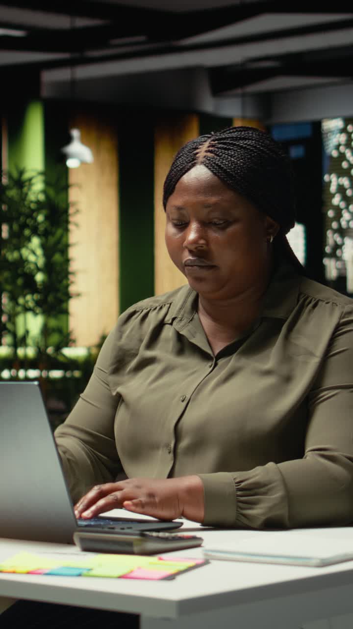 Vertical Video African american woman closing her laptop and office lamp