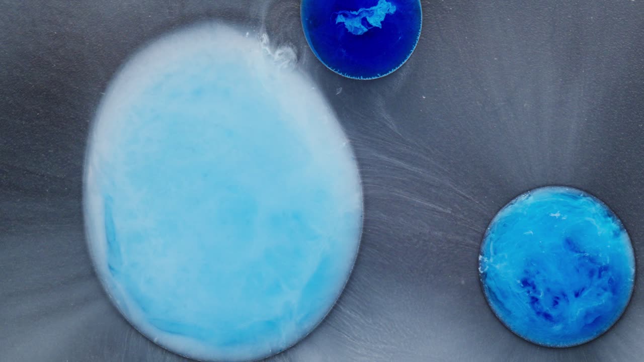 Swirling abstract shapes in blue ink, macro view with dreamy and fluid textures