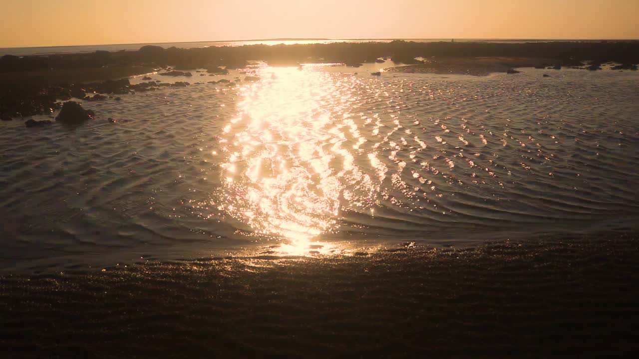 Majestic golden color glitter on tiny ocean water ripples in static view