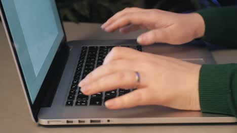 Mujer-Trabajando-En-Un-Macbook-Sobre-La-Mesa