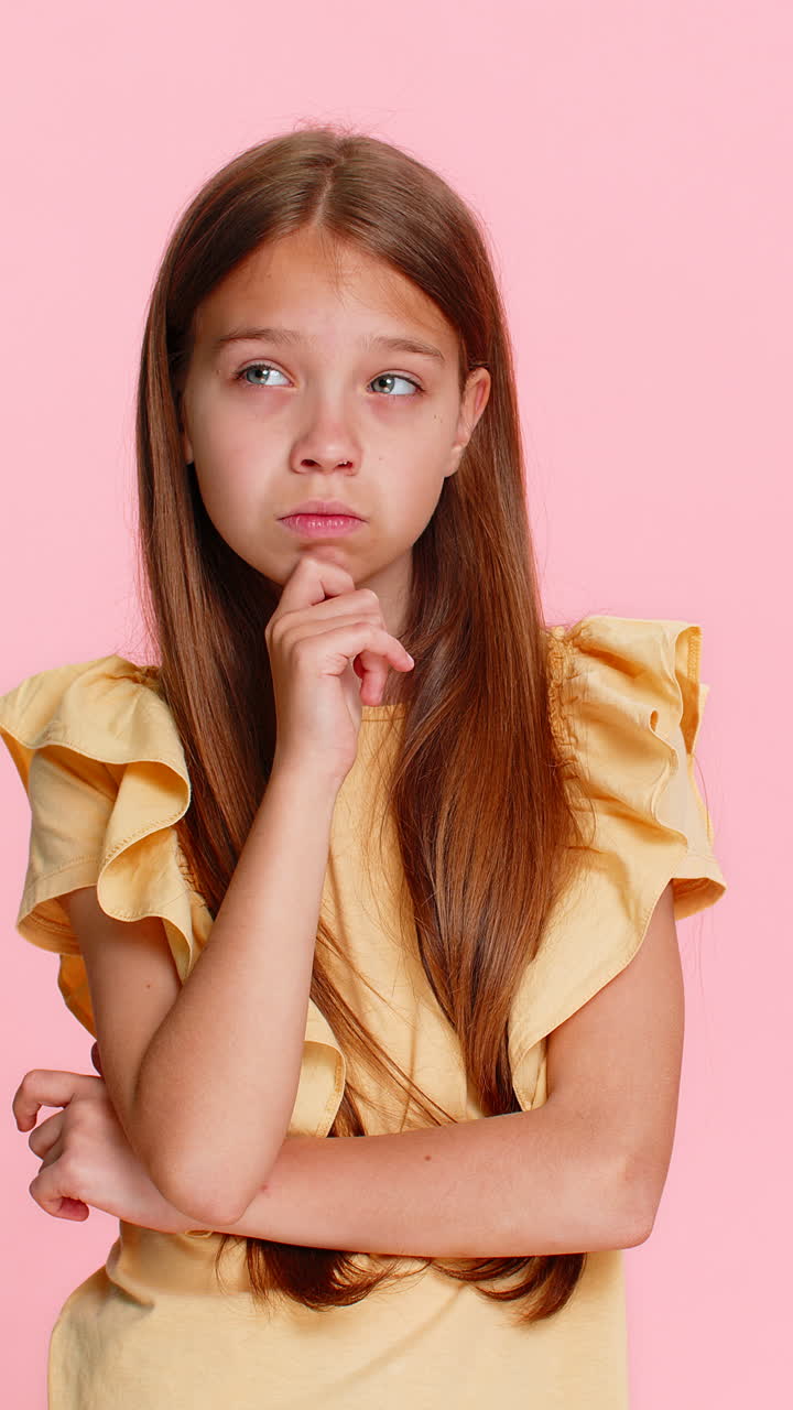 Child girl kid thoughtfully touching chin thinking hard about difficult question solving problem