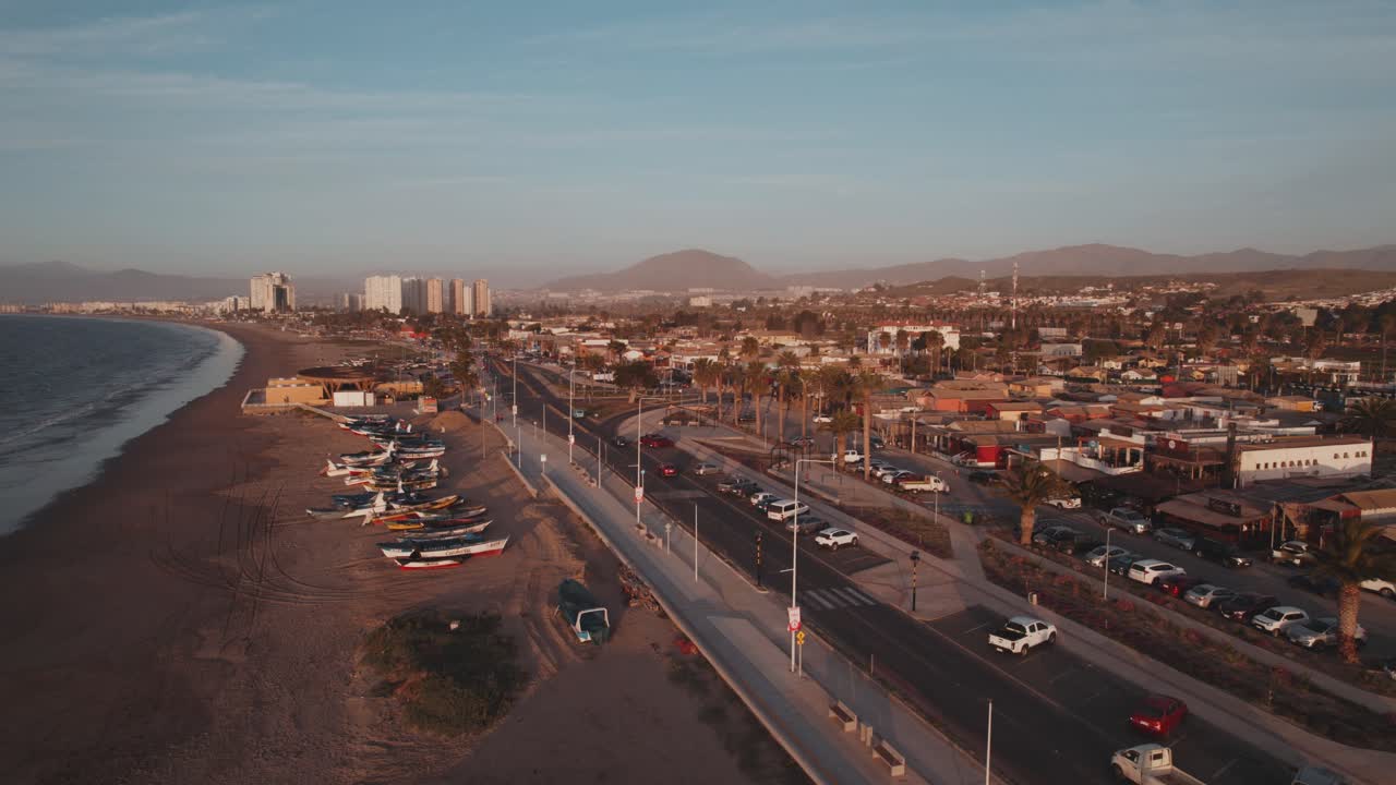 Flyvende over Playa Los Pescadores Strand og Strandpromenaden i Coquimbo, Chile ved solnedgang.