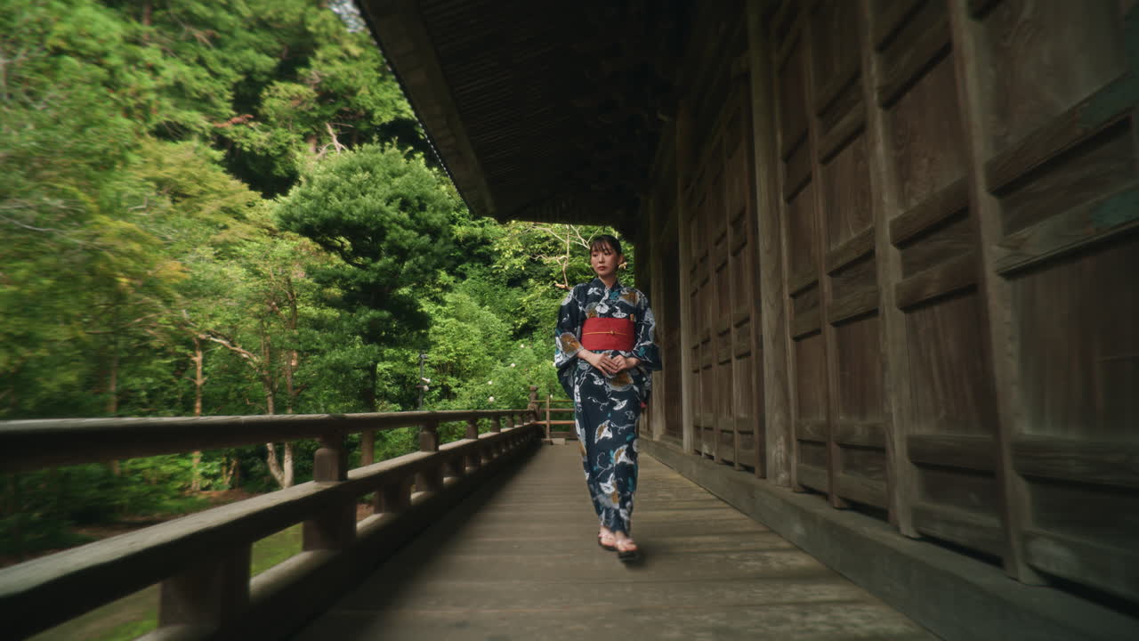 Woman in Kimono Walking Through a Temple Corridor in Japan