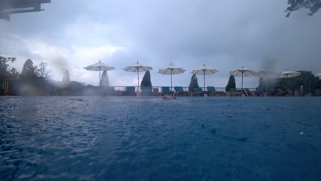 raindrops fall on the water in the pool.