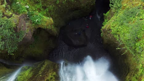 Descending-into-a-Gljufrabui-waterfall-cave-with-Tourists-down-bellow---Iceland