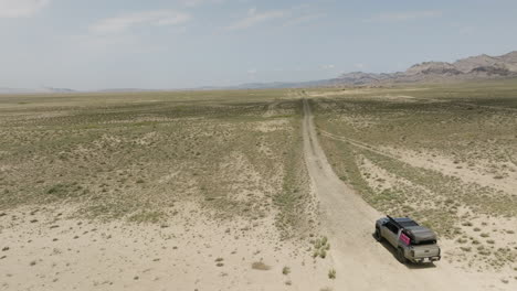 jeep conduciendo por un camino de tierra cruda en una llanura árida de estepa en georgia