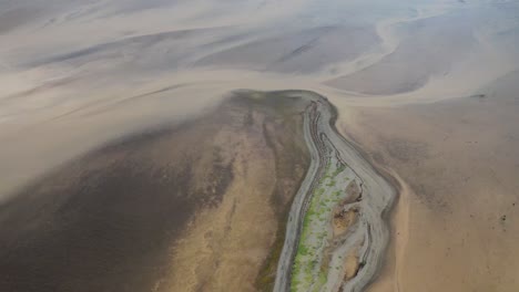 aerial birds eye shot of glacial river delta with melt water on iceland island during foggy day