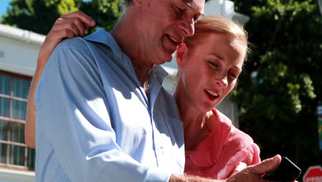 happy couple looking at smartphone together