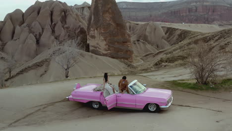 couple in a pink convertible car in cappadocia