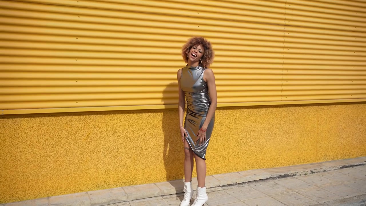 A stylish woman posing confidently and elegantly against a bright yellow background