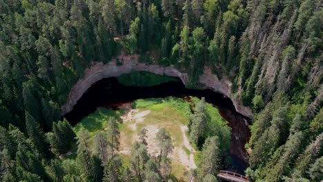 aerial drone view of taevaskoja shows towering sandstone cliffs along the ahja river surrounded by rich green forest offering breathtaking estonian landscape and a peaceful nature experience