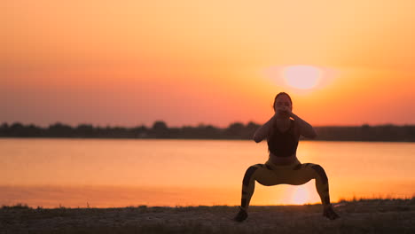 Una-Mujer-Realiza-Abdominales-Al-Atardecer-En-La-Playa-A-Cámara-Lenta.-Ejercitar-Los-Músculos-De-Las-Caderas