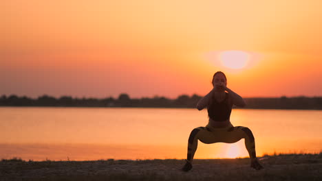 a woman performs sit-ups at sunset on the beach in slow motion. exercise the muscles of the hips