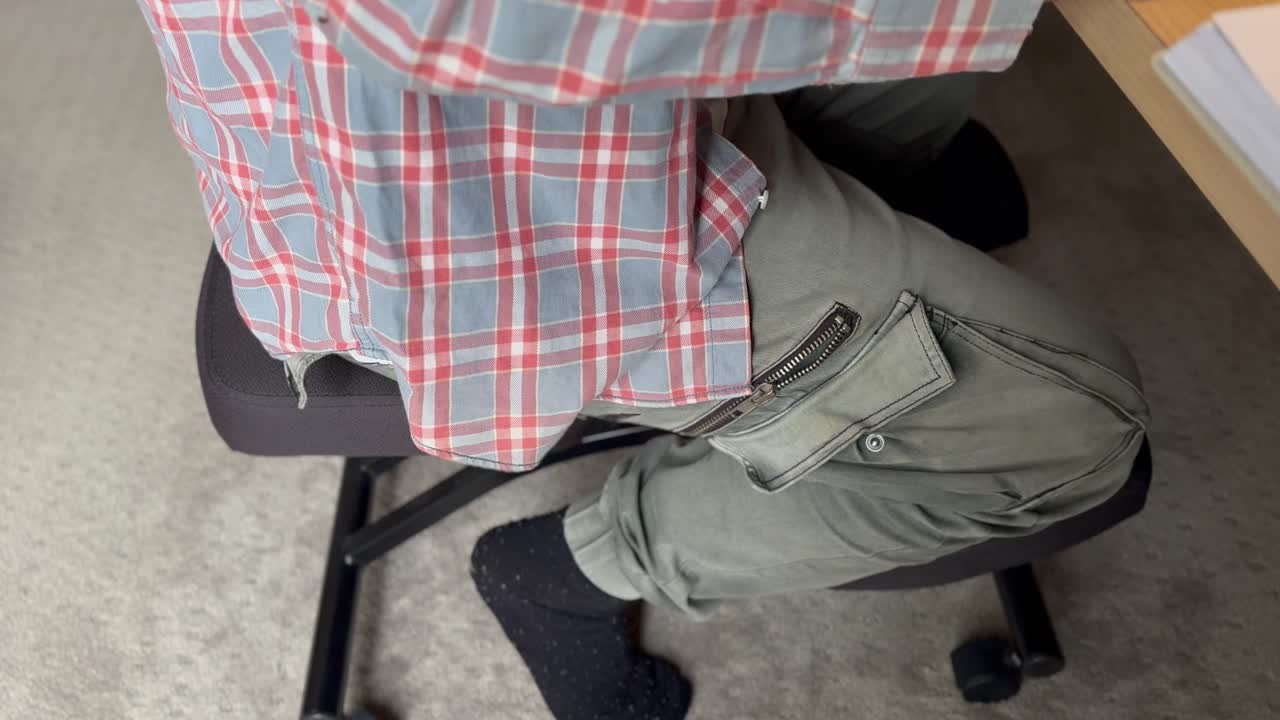 la persona se sienta en una silla ergonómica de rodillas