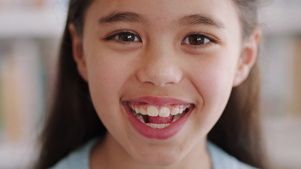 Close-up Portrait of a Young Girl Smiling at the Camera