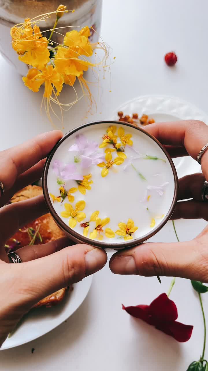 Hand holding a floral-infused drink