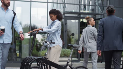 smiling businesswoman ride electric scooter at office after work. city mobility.