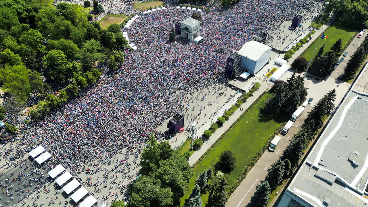 CHISINAU, MOLDOVA - 21 MAY, 2023: Aerial drone view of the rally in support of the country's European integration in Chisinau, Moldova. Thousands of people in the city downtown, greenery, EU and national flags, central park