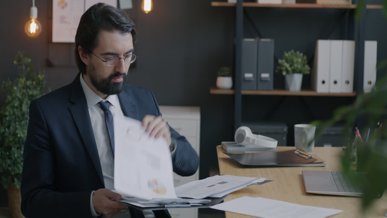 Uomo d'affari che esamina documenti finanziari in ufficio