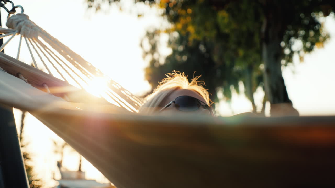 una mujer turista con un vestido de verano se relaja en una hamaca el sol en el horizonte crea un hermoso alto