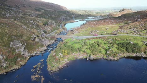 Drone-of-Gap-of-Dunloe,-Bearna-an-Choimín,-narrow-mountain-pass-in-County-Kerry,-Ireland,-that-separates-the-MacGillycuddy's-Reeks-mountain-range-and-the-Purple-Mountain-Group