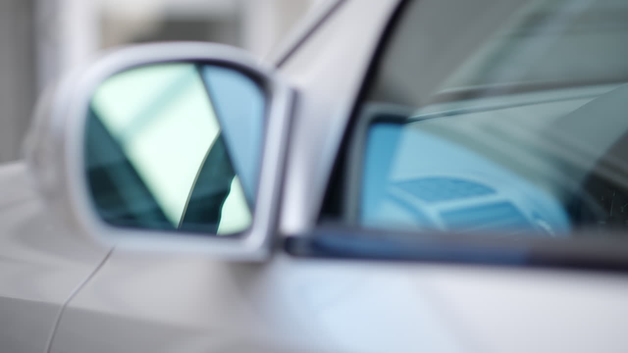 Close up of the mirror and the front window of a silver car