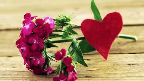 Bunch-of-pink-flowers-on-wooden-plank