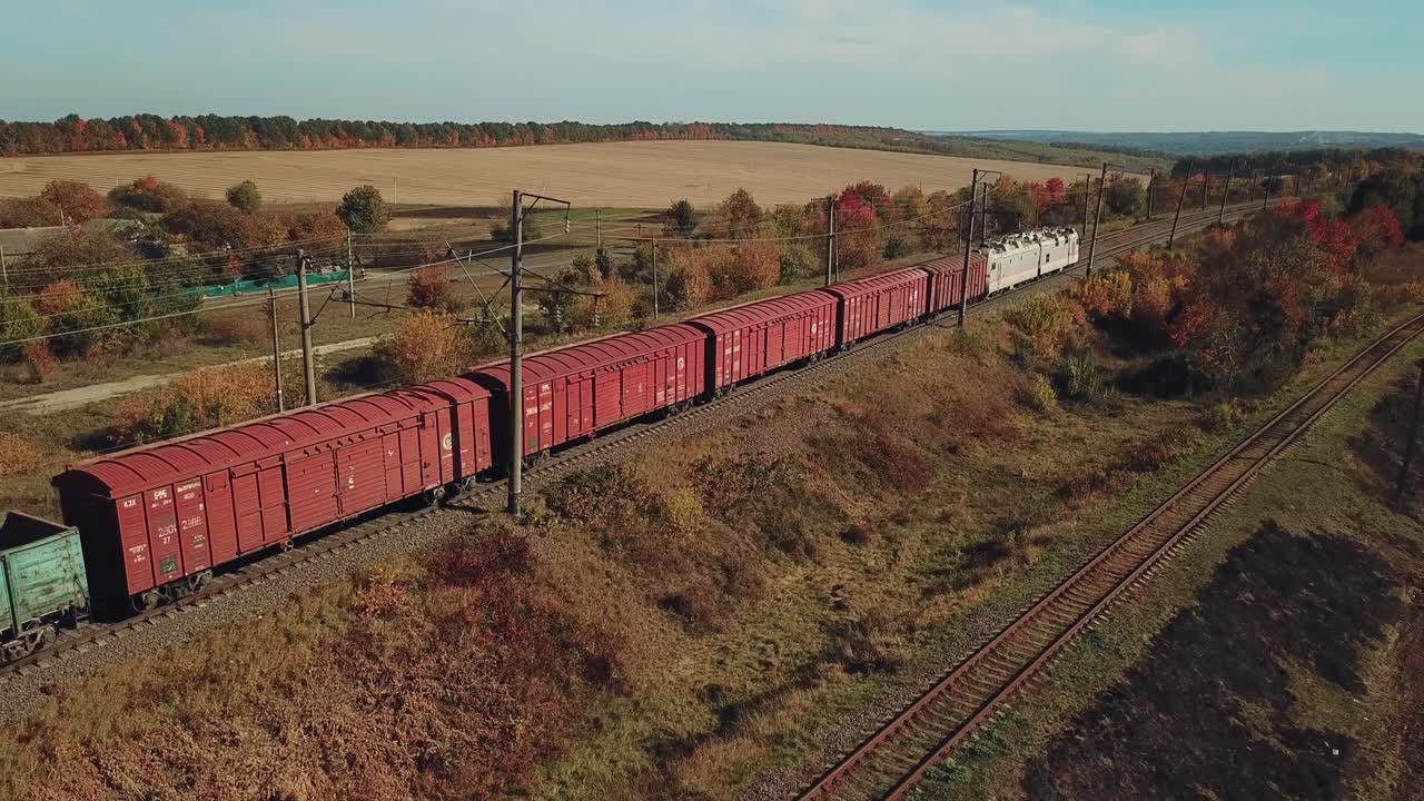 freight train with building materials is passing by rail to the destination. Aerial view