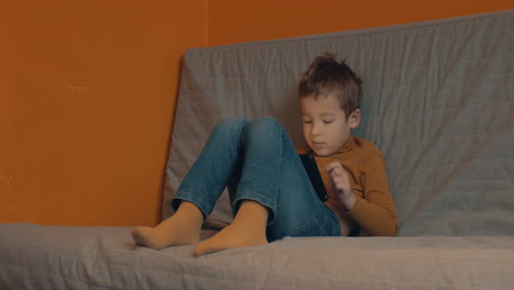 Child-relaxing-with-tablet-computer-at-home