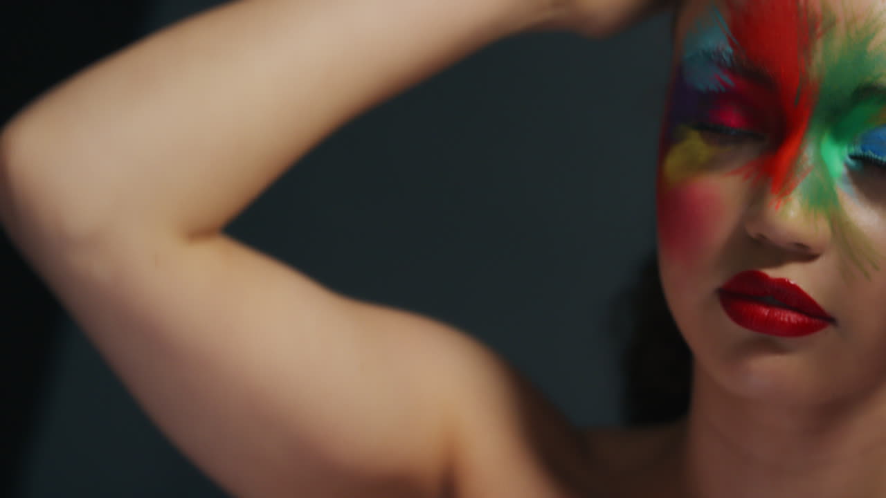 ritratto ravvicinato di una bella donna che indossa un viso colorato vernice esotica arte del corpo multicolore femminile sensuale che gode dell'espressione creativa