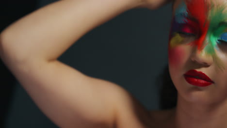 retrato de cerca de una mujer hermosa con una pintura de rostro colorida arte corporal multicolor exótico mujer sensual que disfruta de la expresión creativa