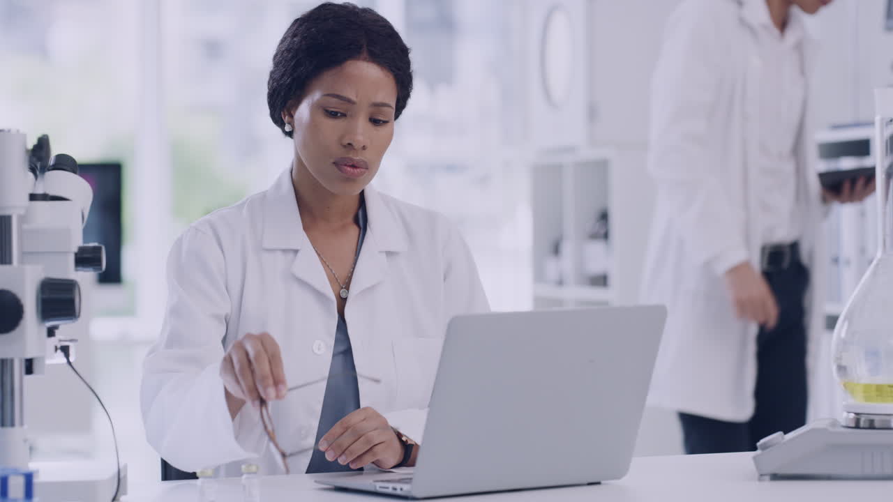 científico estresado trabajando en una computadora portátil en un laboratorio