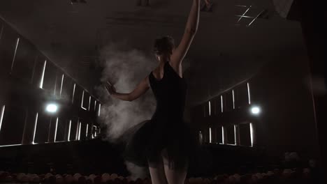 ballerina is practicing her moves in dark studio. young girl dancing with air white dress tutu, spinning around and smiling. gracefulness and tenderness in every movement.