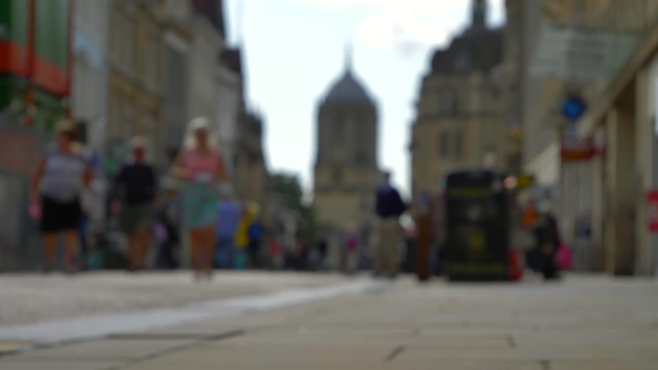 campo lungo sfocato di pedoni che camminano per cornmarket street a oxford