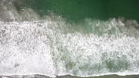 Vista-Cenit-Desde-Un-Dron-Sobre-La-Costa-Moviéndose-Lentamente-Hacia-El-Mar