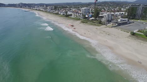 surfistas y bañistas en verano en la playa tallebudgera con aguas azules brillantes y arena blanca en la costa dorada de australia