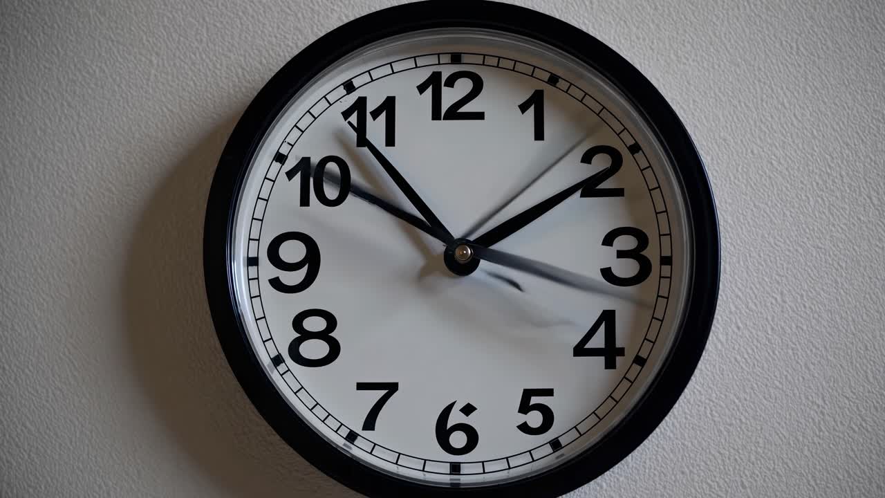 Primo piano di un classico orologio da parete con cornice nera, quadrante bianco e numeri ben visibili, perfetto