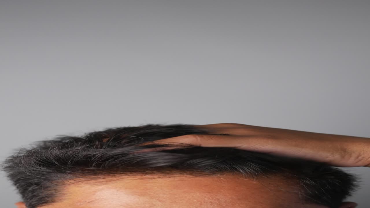 머리를 만지는 사람은 머리카락이 빠지는 것에 대해 걱정하는 것 같습니다.