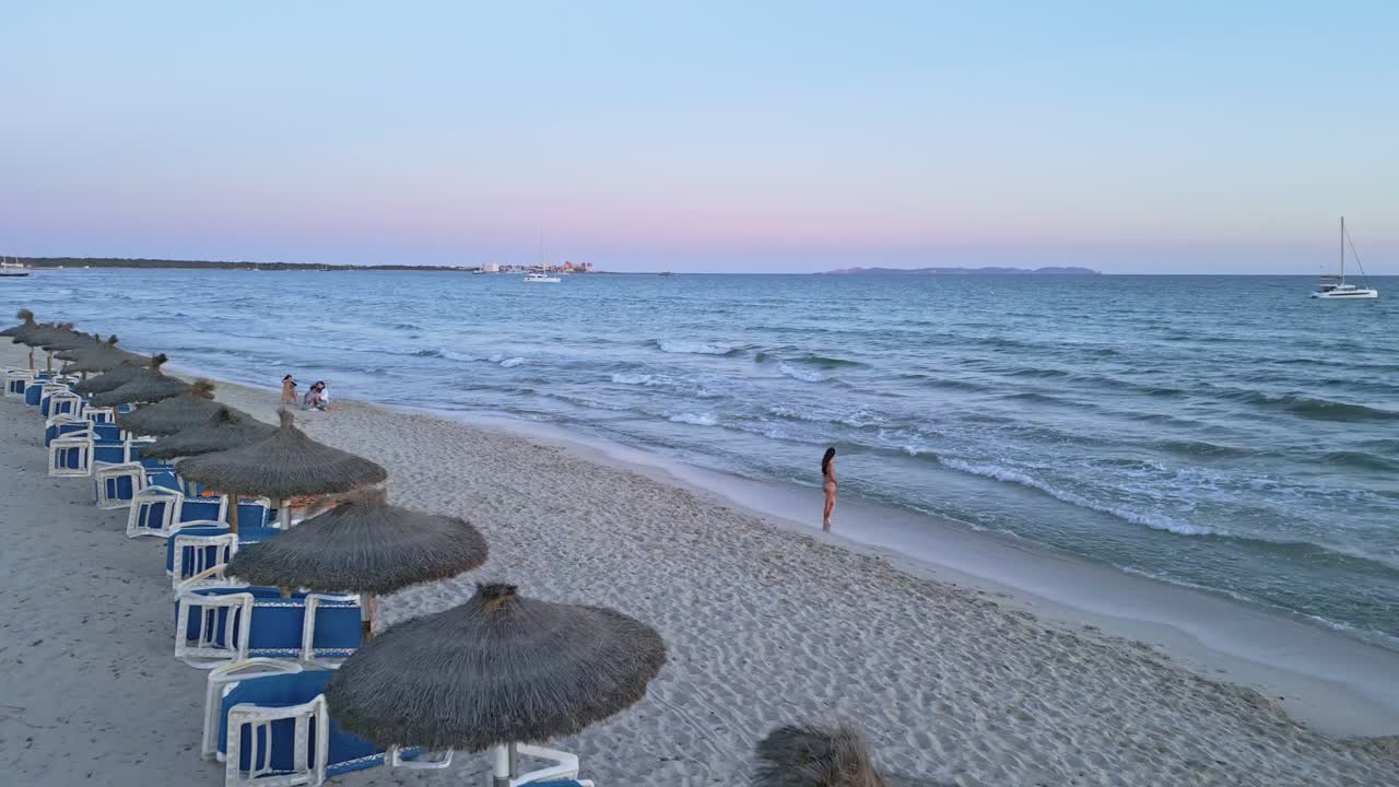 Woman in Bikini Relaxing on a Beach at Sunset