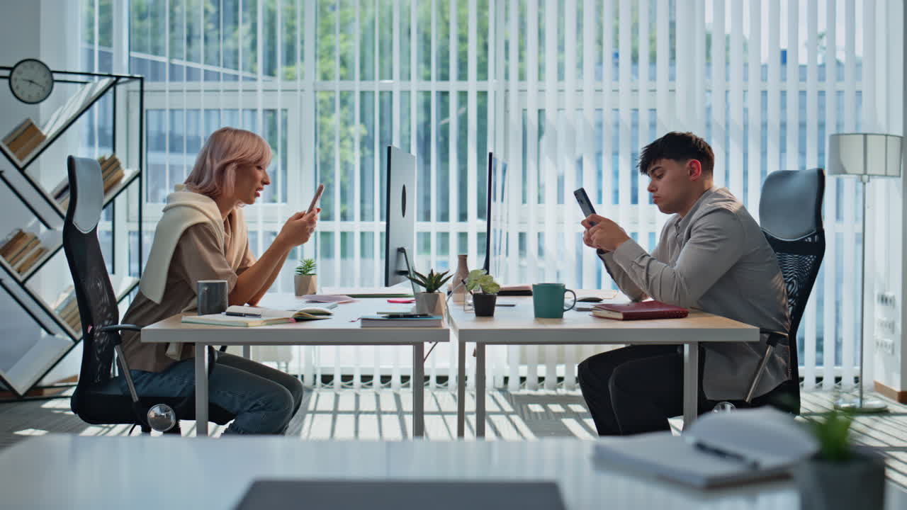 Fatigued colleagues looking smartphones resting office closeup. Tired coworkers