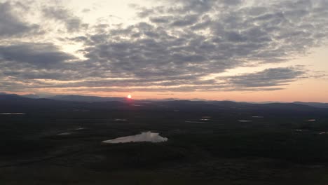 Toma-De-Drones-De-La-Campiña-De-Kiruna-Laponia-Durante-La-Puesta-De-Sol-Con-Montañas-En-El-Horizonte