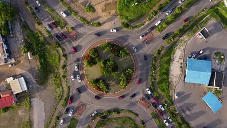 Luftaufnahme-Von-Oben-Nach-Unten,-Rotierender-Tropischer-Kreisverkehr,-Während-Autos-Zur-Hauptverkehrszeit-Ein--Und-Ausfahren